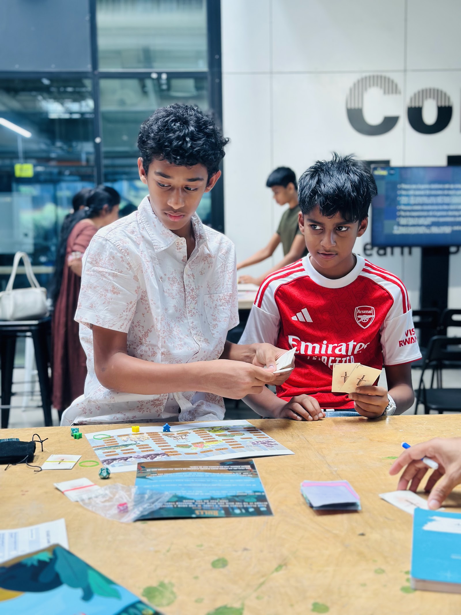 The balancing session — students reworking rules after a playtest